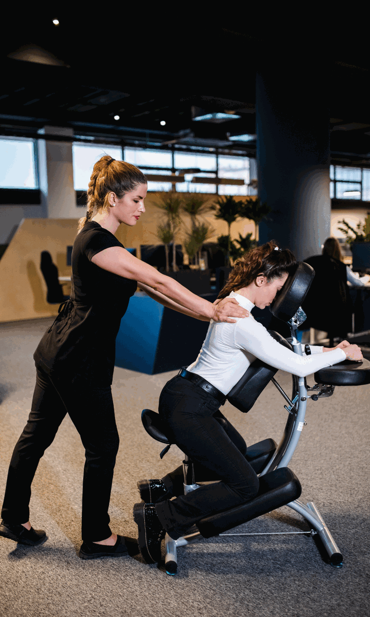 Therapist giving a chair massage at a corporate wellness event