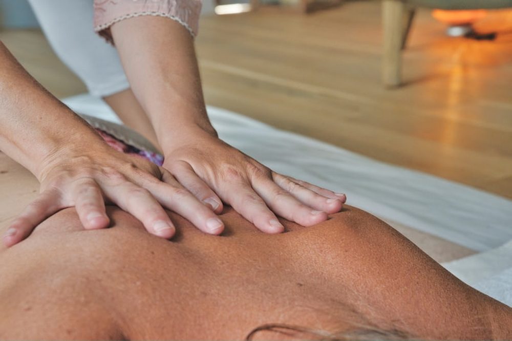 Therapist applying firm two-handed deep tissue pressure during a deep tissue massage near Reading, PA