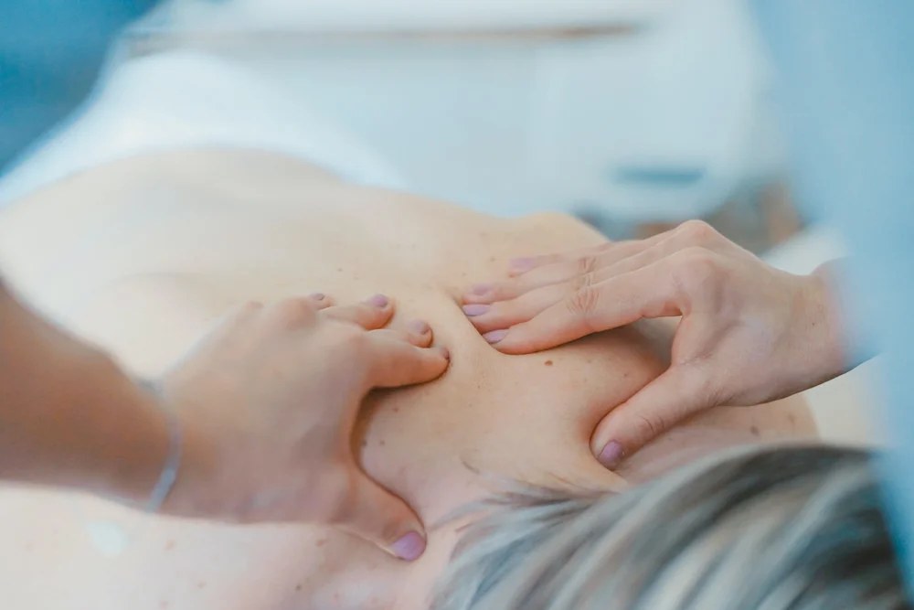 Therapist applying focused pressure to the muscles of the lower back